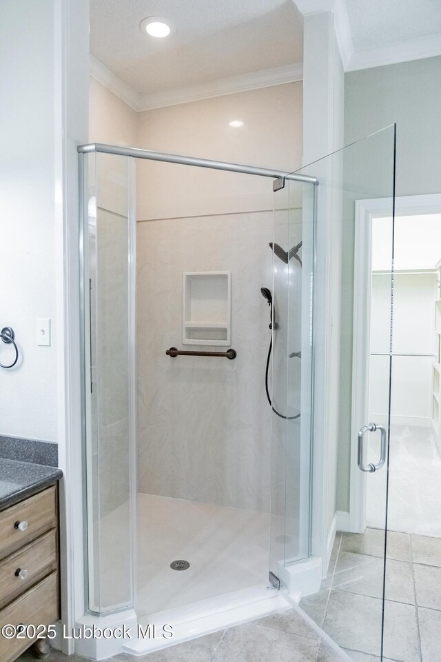 9805 Savannah Ave, Lubbock, TX 79424 - full bathroom featuring crown molding, a shower stall, tile patterned floors, and vanity