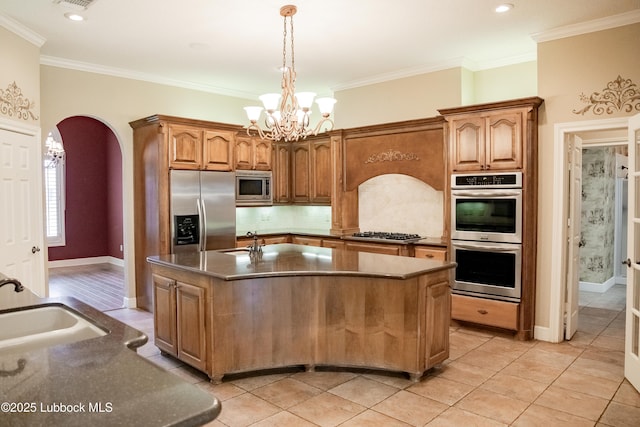 9805 Savannah Ave, Lubbock, TX 79424 - kitchen featuring stainless steel appliances, a sink, arched walkways, a chandelier, and backsplash