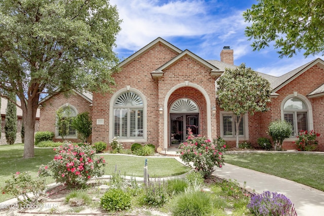 9805 Savannah Ave, Lubbock, TX 79424 - view of front of property featuring brick siding, a front lawn, and a chimney