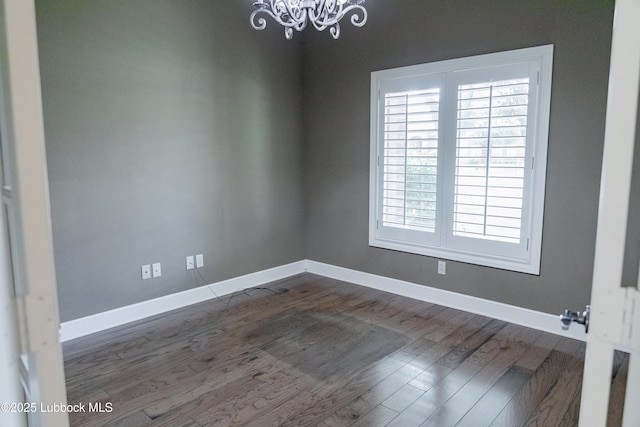 9805 Savannah Ave, Lubbock, TX 79424 - empty room with a chandelier, baseboards, and dark wood-style floors