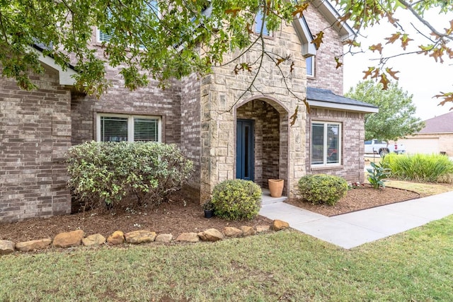 view of front of home featuring brick siding and a front lawn