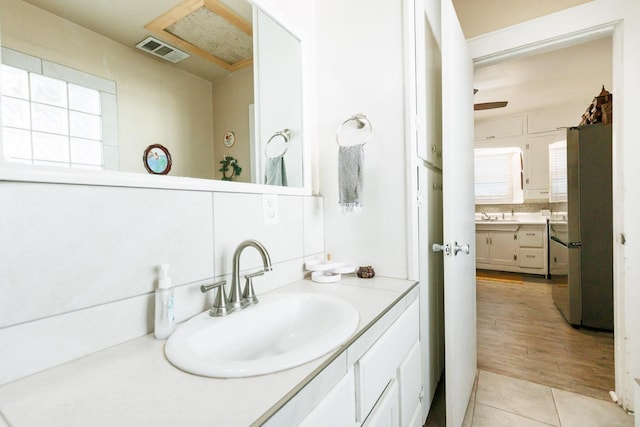 bathroom with tile patterned floors, vanity, and decorative backsplash