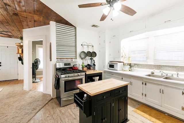 kitchen featuring white cabinetry, sink, stainless steel range with gas cooktop, and light hardwood / wood-style floors