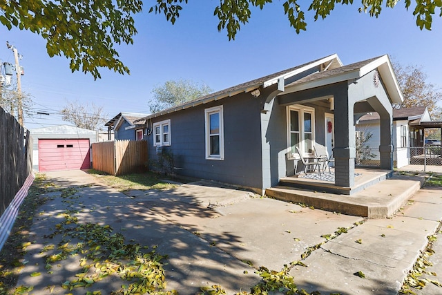 view of front of property featuring a garage, an outdoor structure, and covered porch