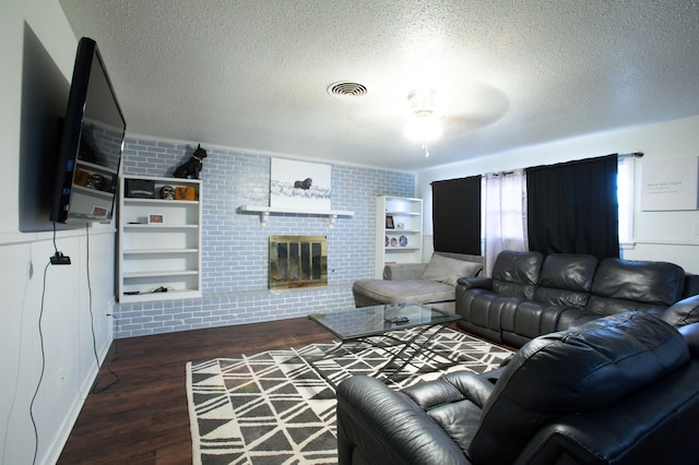 5426 9th St, Lubbock, TX 79416 - living area with wood finished floors, a textured ceiling, a brick fireplace, and ceiling fan