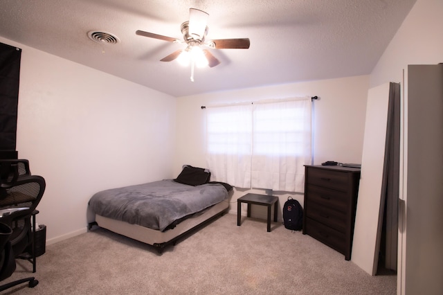 5426 9th St, Lubbock, TX 79416 - bedroom featuring light carpet, a textured ceiling, and a ceiling fan