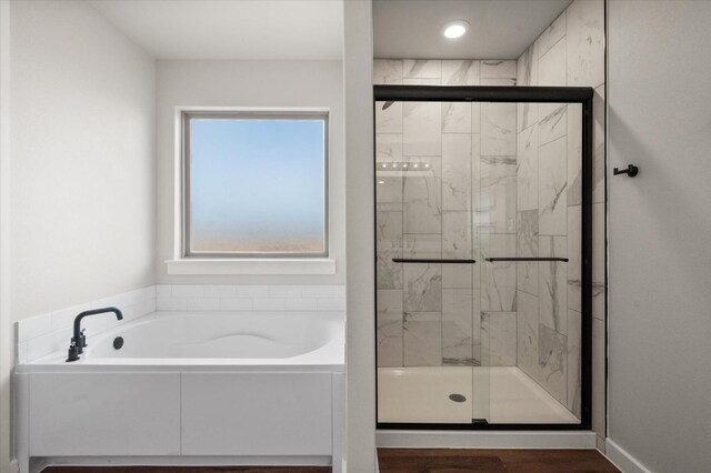 bathroom with hardwood / wood-style floors, a wealth of natural light, and separate shower and tub