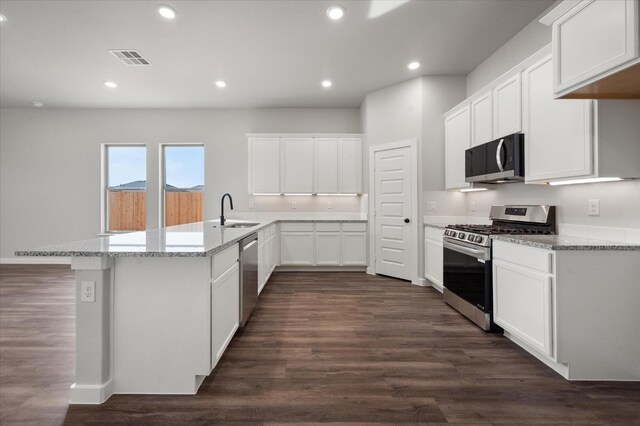 kitchen with sink, appliances with stainless steel finishes, dark hardwood / wood-style floors, light stone counters, and white cabinets