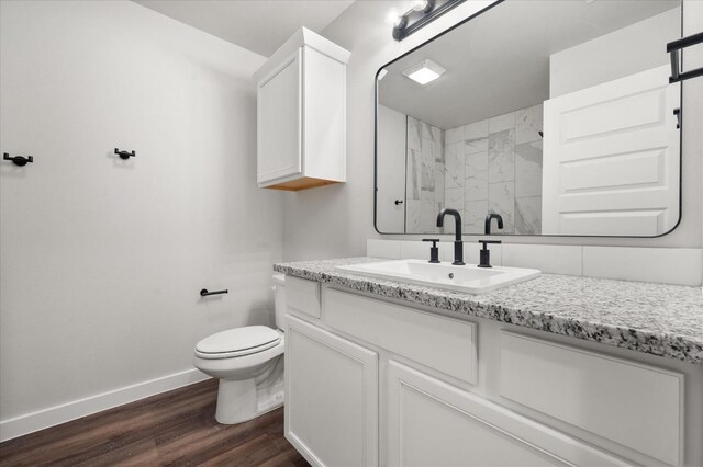 bathroom with wood-type flooring, toilet, vanity, and a shower