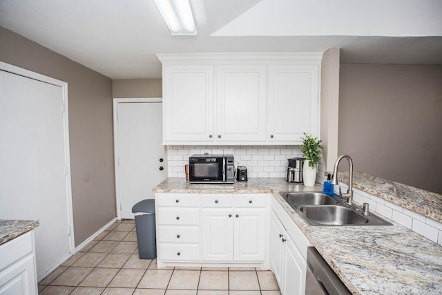 kitchen with sink, light tile patterned floors, white cabinets, and decorative backsplash