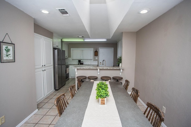 dining area featuring sink and light tile patterned floors