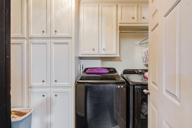 washroom with cabinets and washer and dryer