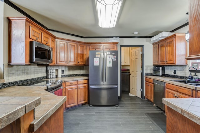 kitchen featuring backsplash, sink, and appliances with stainless steel finishes