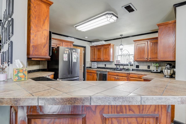 kitchen featuring tile countertops, stainless steel appliances, and kitchen peninsula