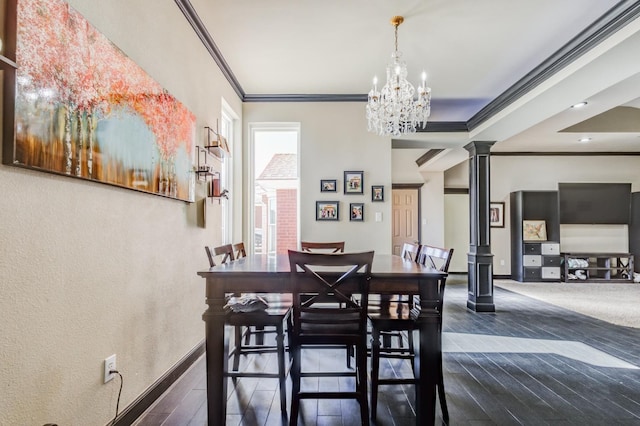 dining room with ornamental molding, dark hardwood / wood-style flooring, a chandelier, and ornate columns