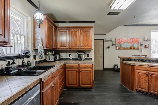 kitchen with decorative light fixtures, sink, backsplash, stainless steel dishwasher, and tile counters