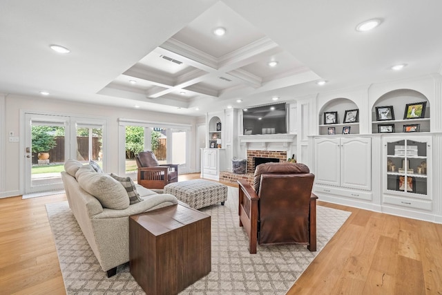 living room featuring built in features, beam ceiling, coffered ceiling, a fireplace, and light hardwood / wood-style floors