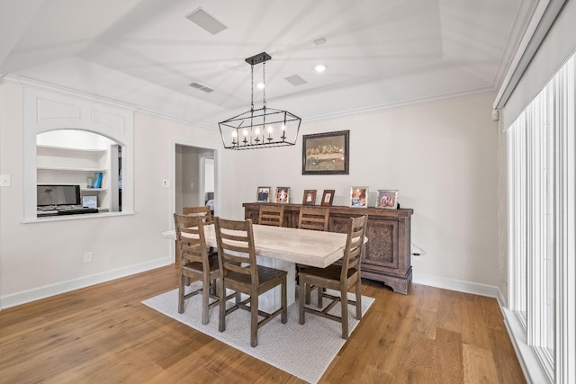 dining area featuring crown molding, built in features, and light hardwood / wood-style flooring