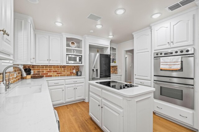 kitchen featuring white cabinetry, appliances with stainless steel finishes, sink, and a kitchen island