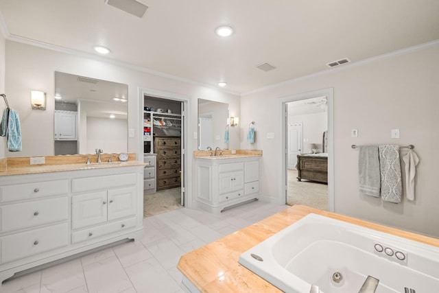 bathroom featuring vanity, a washtub, and crown molding