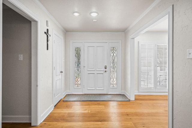 foyer entrance featuring crown molding and light hardwood / wood-style floors