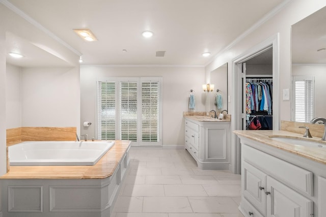 bathroom with crown molding, vanity, and a bathtub