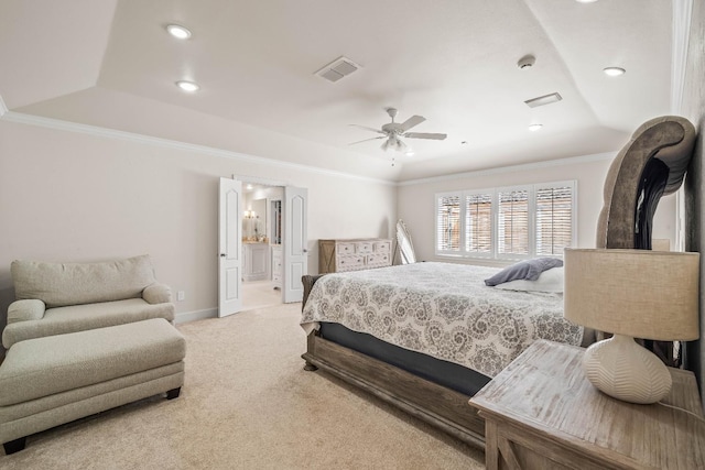 carpeted bedroom featuring crown molding, ensuite bath, a raised ceiling, and ceiling fan