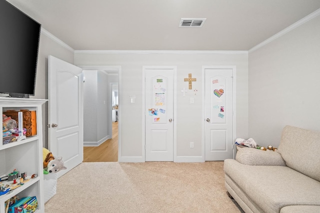 rec room with ornamental molding and light colored carpet