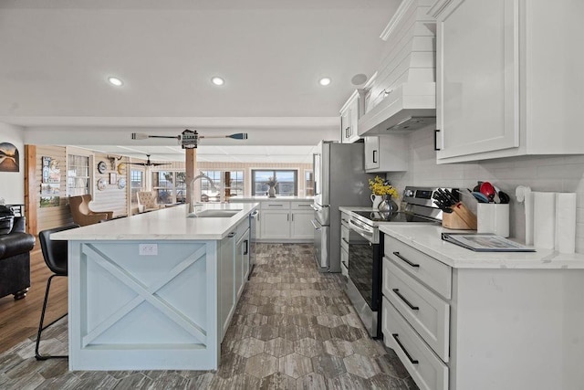 kitchen featuring appliances with stainless steel finishes, sink, white cabinets, and a kitchen bar