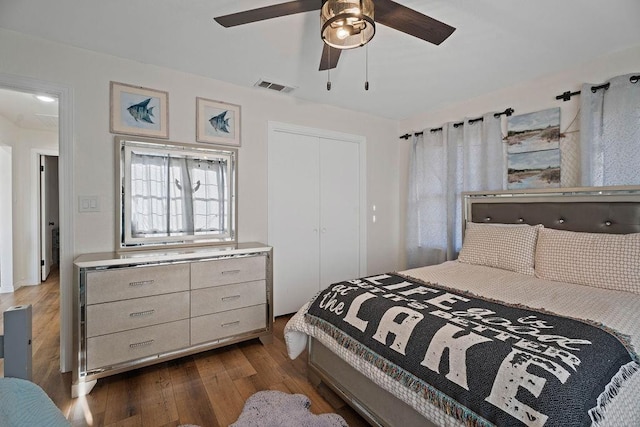 bedroom with dark hardwood / wood-style floors, ceiling fan, and a closet