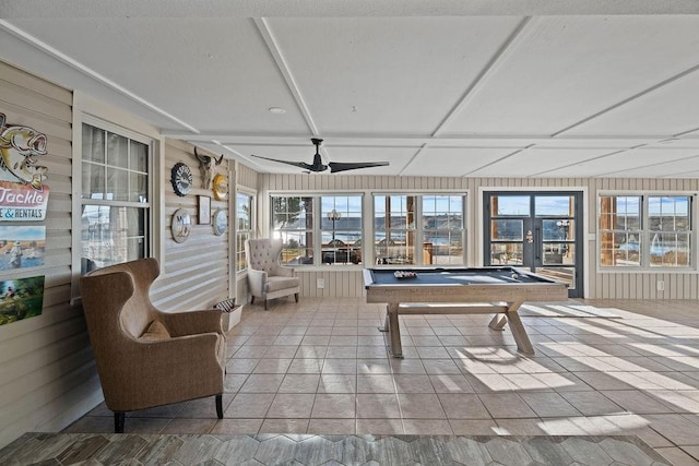 playroom with a healthy amount of sunlight, light tile patterned floors, and wooden walls