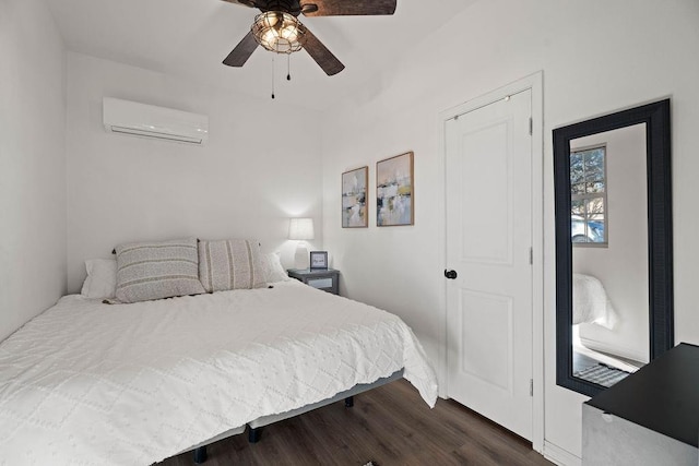 bedroom featuring dark hardwood / wood-style flooring, an AC wall unit, and ceiling fan