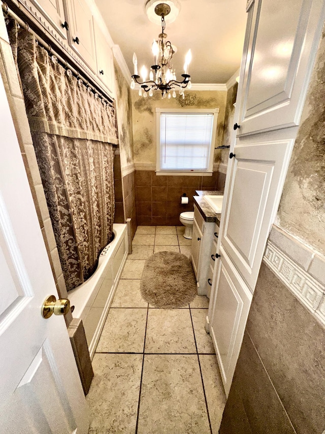 bathroom with wainscoting, toilet, ornamental molding, an inviting chandelier, and vanity