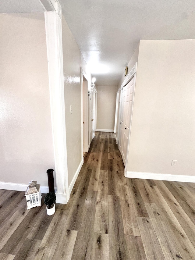 hall featuring baseboards and wood finished floors