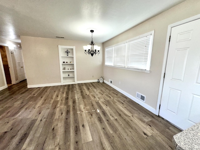 unfurnished dining area with dark wood-type flooring, visible vents, and baseboards