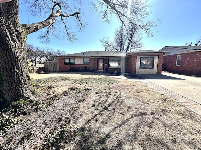 single story home with brick siding and fence