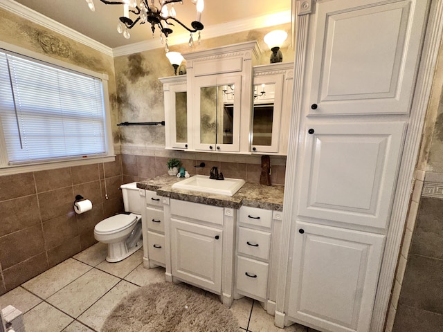 bathroom with tile walls, tile patterned floors, crown molding, vanity, and a notable chandelier