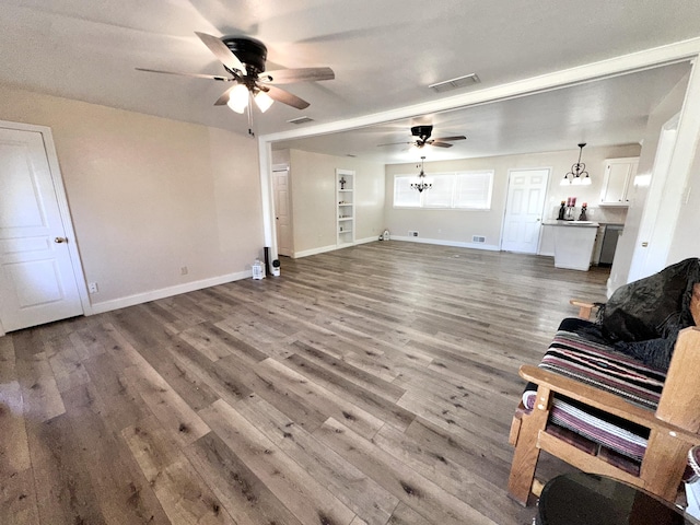 living room with ceiling fan, wood finished floors, visible vents, and baseboards