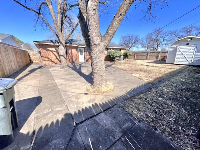 exterior space featuring an outbuilding, a patio area, a fenced backyard, and a storage unit