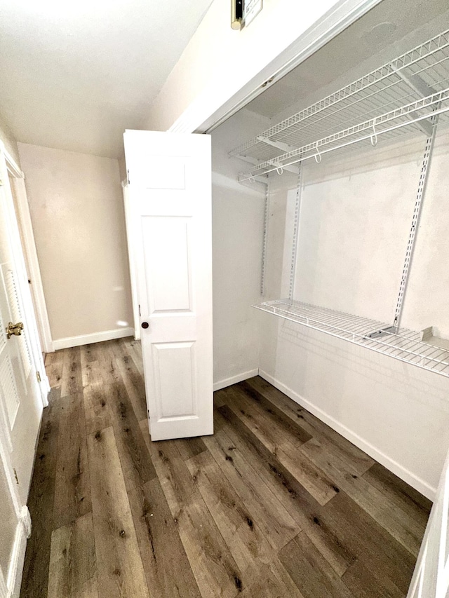 walk in closet with wood finished floors