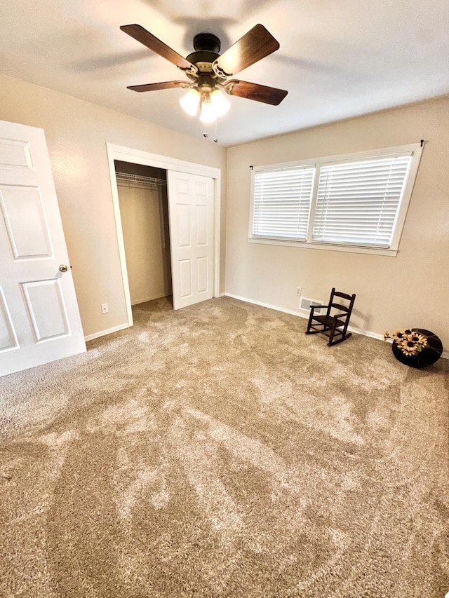 unfurnished bedroom featuring carpet, baseboards, ceiling fan, and a closet