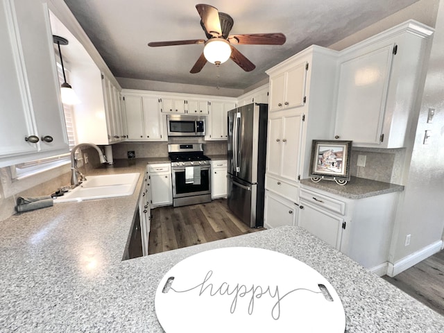 kitchen with white cabinetry, appliances with stainless steel finishes, backsplash, and a sink