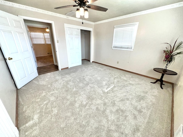 unfurnished bedroom with ornamental molding, a closet, carpet, and baseboards