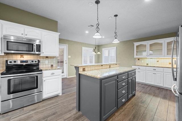 kitchen featuring gray cabinets, stainless steel appliances, a center island, white cabinets, and decorative light fixtures