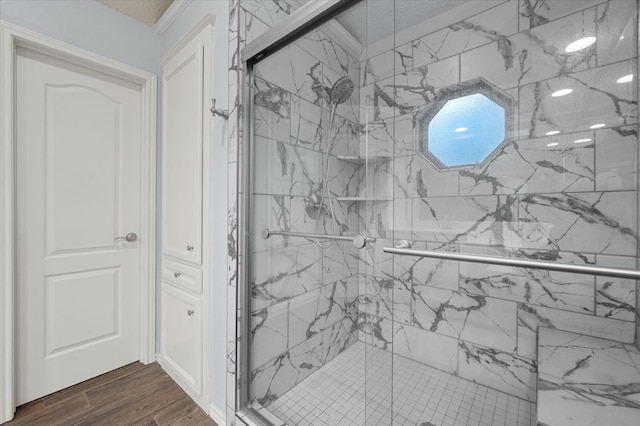 bathroom with hardwood / wood-style floors and a shower with shower door