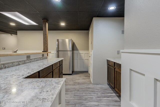 4517 9th St, Lubbock, TX 79416 - kitchen with freestanding refrigerator, light wood-style flooring, a drop ceiling, and recessed lighting