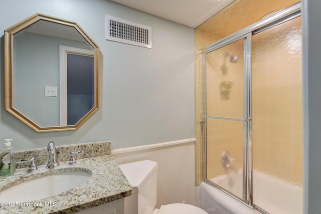 4517 9th St, Lubbock, TX 79416 - bathroom featuring toilet, enclosed tub / shower combo, vanity, and a wainscoted wall