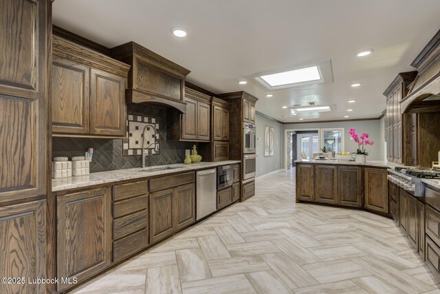 4517 9th St, Lubbock, TX 79416 - kitchen featuring appliances with stainless steel finishes, a sink, a peninsula, recessed lighting, and decorative backsplash