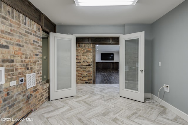 4517 9th St, Lubbock, TX 79416 - empty room featuring french doors, baseboards, and brick wall