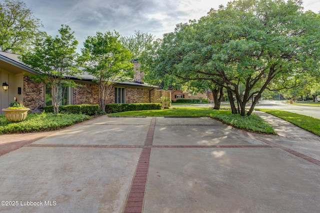 4517 9th St, Lubbock, TX 79416 - view of front of house featuring a chimney, uncovered parking, and brick siding